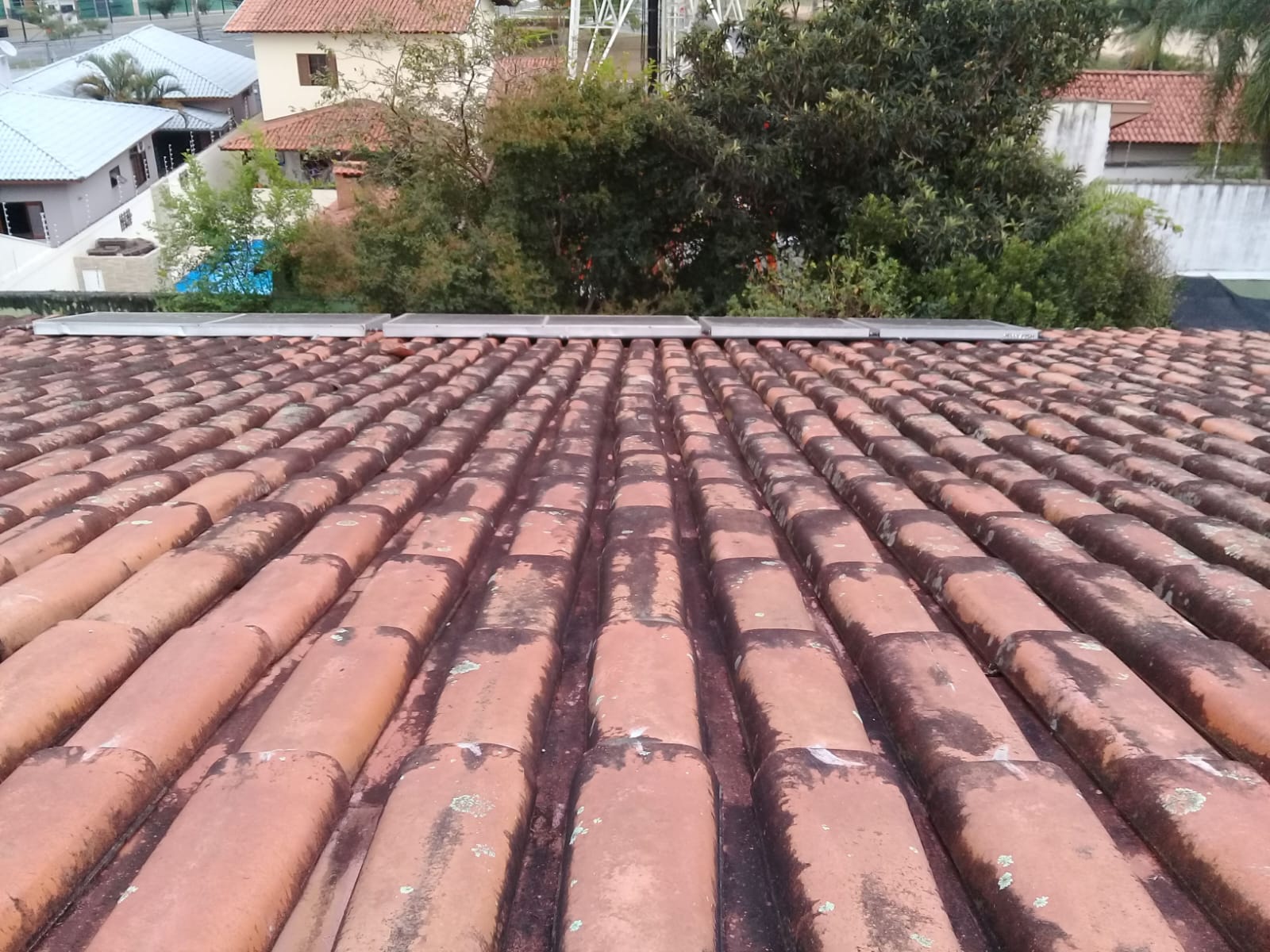 Telhado residencial com telhas de barro apresentando musgos e sujidades, vista de cima que mostra bem o tipo de trabalho realizado em São José dos Campos.