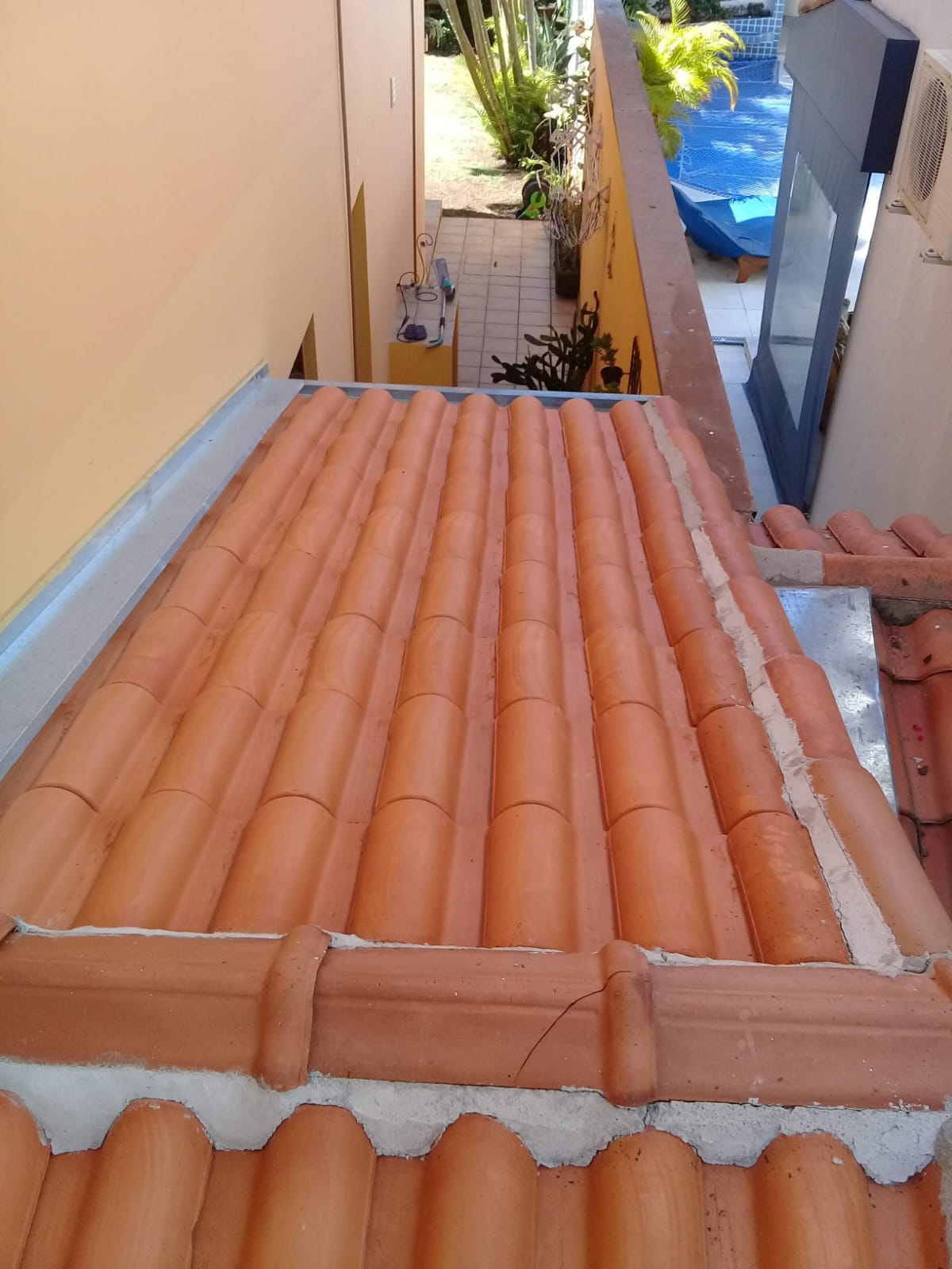 Telhado residencial com telhas cerâmicas limpas, mostrando o resultado do serviço de lavagem realizado.